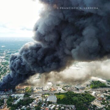 Helicóptero cisterna sobrevuela incendio para mitigar llamas en almacenes #PlazaLama | Vía @LunaValienteRD