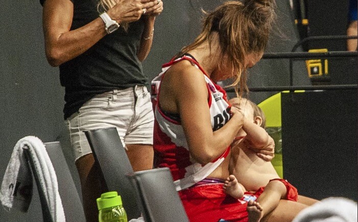 Imagen de jugadora de baloncesto que amamanta durante el entretiempo de un partido